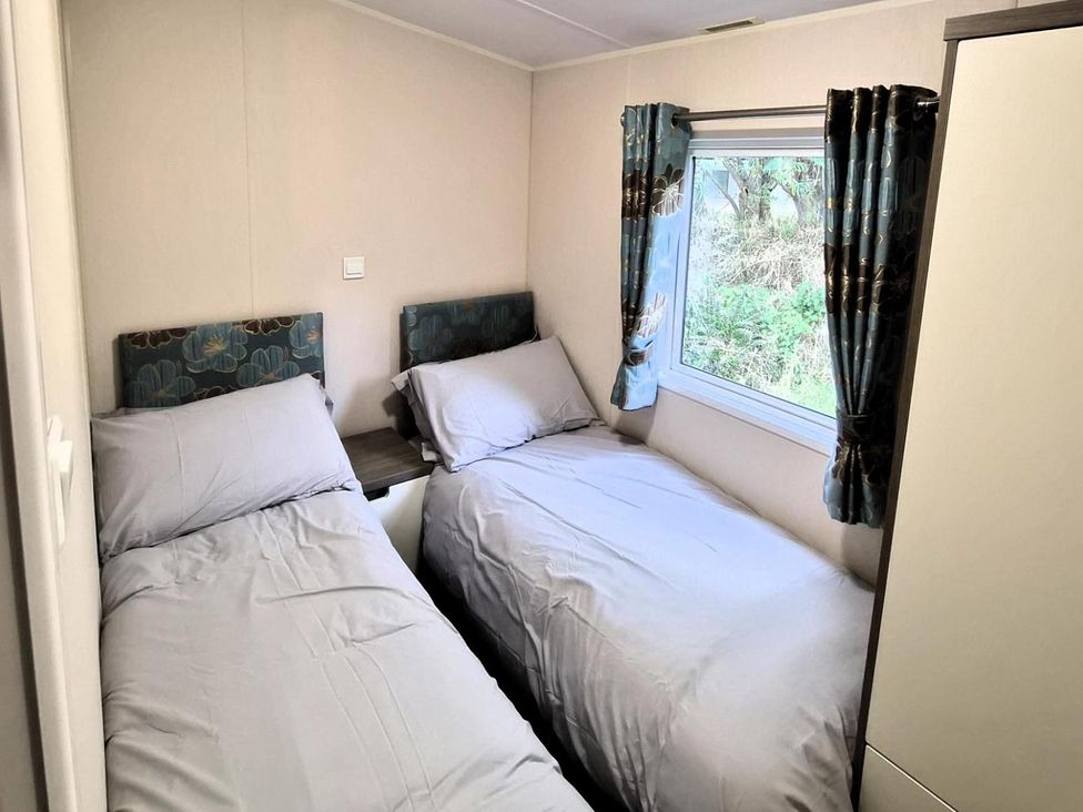 A bedroom with two single beds at Homely Caravan in Skegness