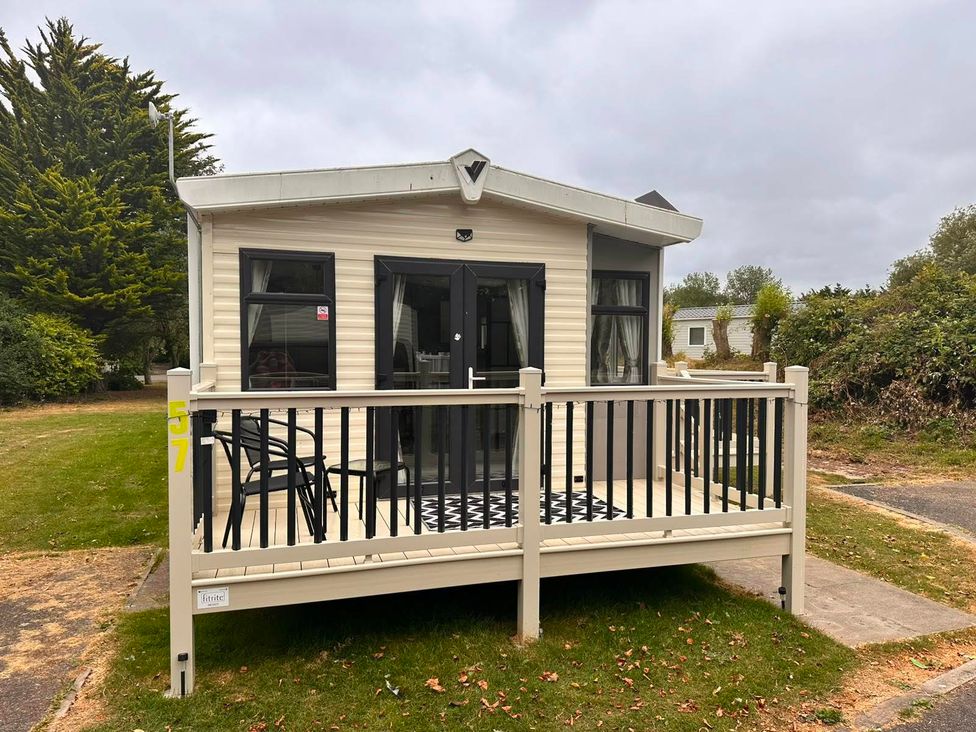 A caravan with a deck and chairs at Homely Caravan in Skegness