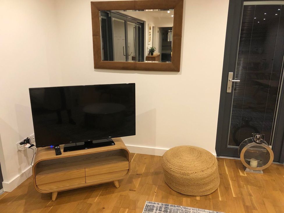 A living room with a television and a mirror at the property in Tyler Hill near Canterbury