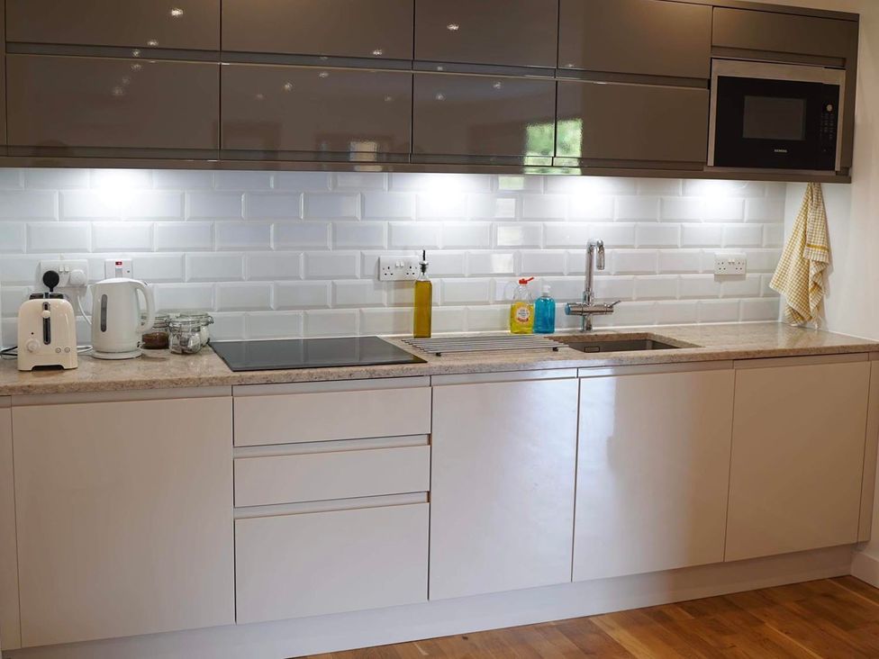 A kitchen with countertop, sink, kettle, toaster, and microwave at Tyler Hill near Canterbury