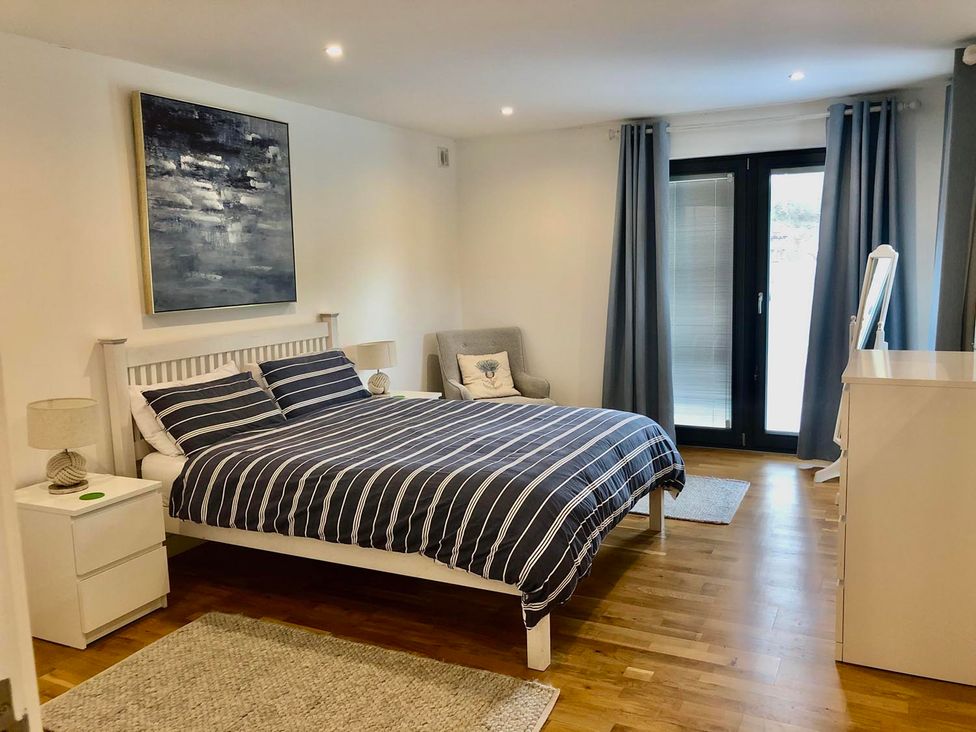 A bedroom featuring a bed, nightstands, a chair, and a dressing table at the property in Tyler Hill near Canterbury
