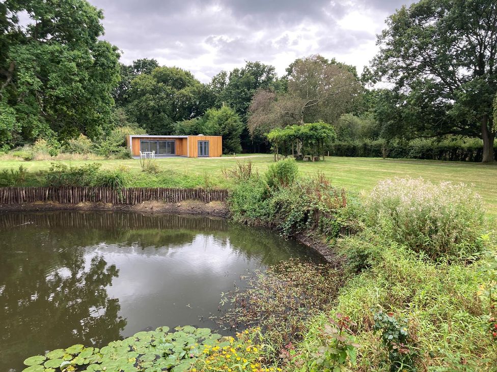 An outdoor area with a pond and a modern building at an unspecified location