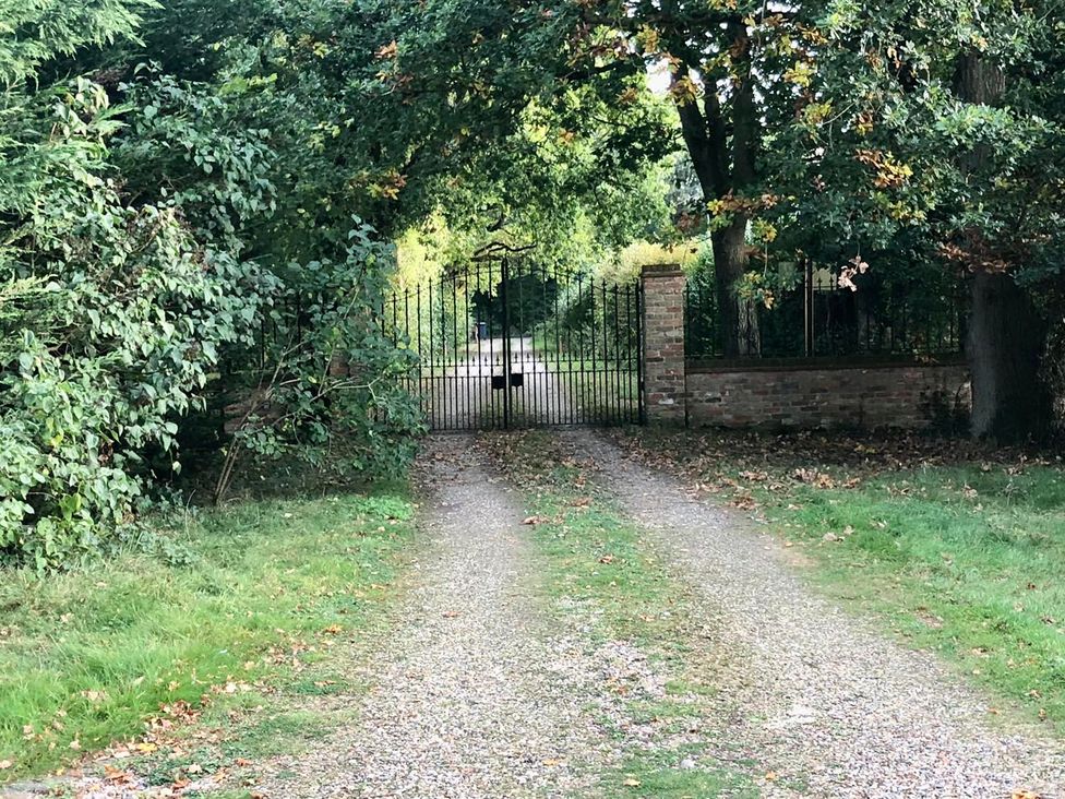 A driveway leading to a gated entrance in a garden at Tyler Hill near Canterbury