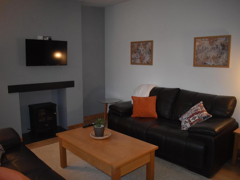 A living room with a sofa, coffee table, and television at Pet friendly Cabin Sleeps 6 with Parking and Garden in Penygroes