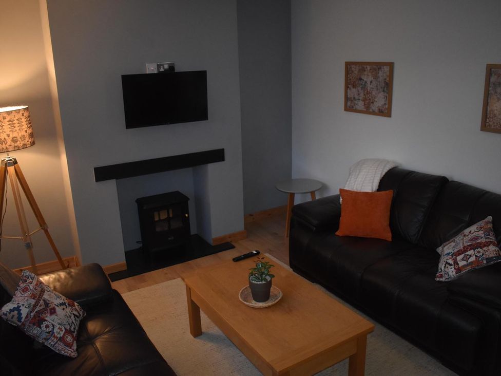 A living room with a coffee table and television at Pet friendly Cabin Sleeps 6 with Parking and Garden in Penygroes