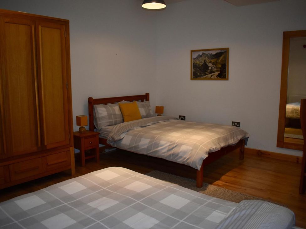 A bedroom with a bed, wardrobe and nightstand at Pet friendly Cabin Sleeps 6 with Parking and Garden, Penygroes