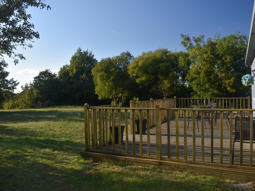 A deck with chairs and a table at Pet friendly Cabin Sleeps 6 with Parking and Garden in Penygroes