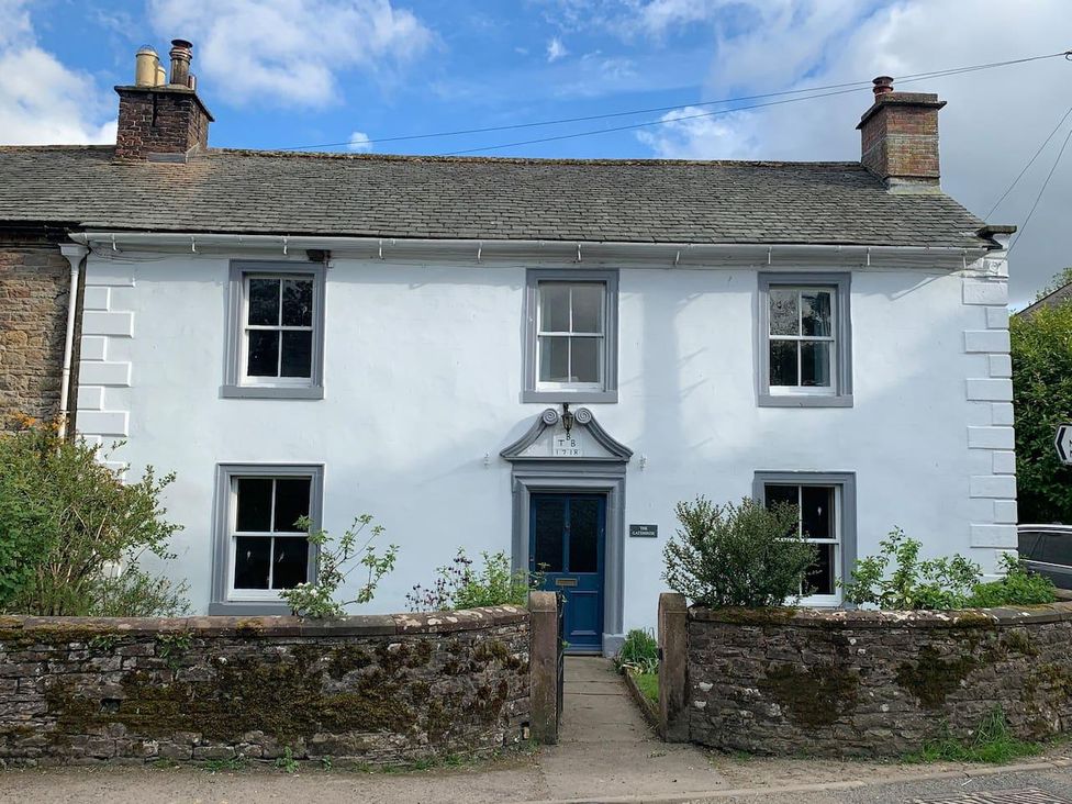 A house with a blue front door and windows at House Sleeps 10 Pet friendly Parking Caldbeck