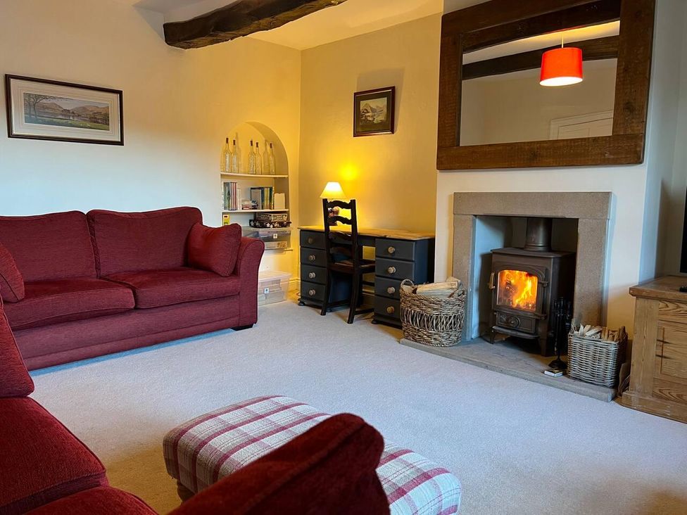 A living room with a sofa and fireplace at House Sleeps 10 Pet friendly Parking in Caldbeck