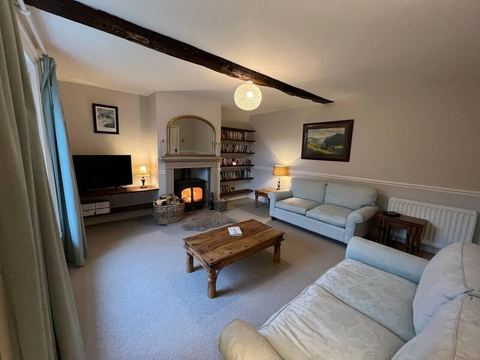 A living room with a sofa and fireplace at House Sleeps 10 Pet friendly Parking in Caldbeck