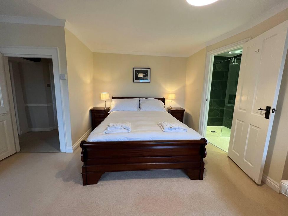 A bedroom with a bed and bathroom access at House Sleeps 10 Pet friendly Parking Caldbeck