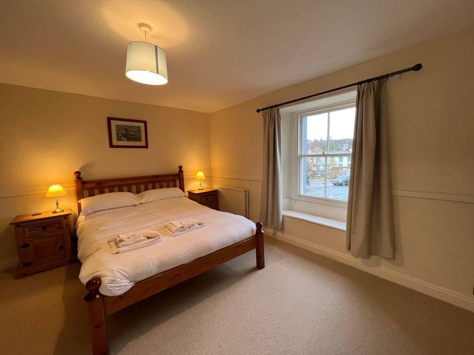 A bedroom with a bed and nightstands at House Sleeps 10 Pet friendly Parking in Caldbeck