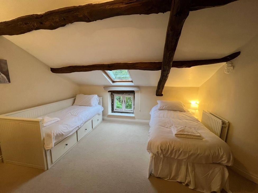 A bedroom with two beds and a window at House Sleeps 10 Pet friendly Parking in Caldbeck