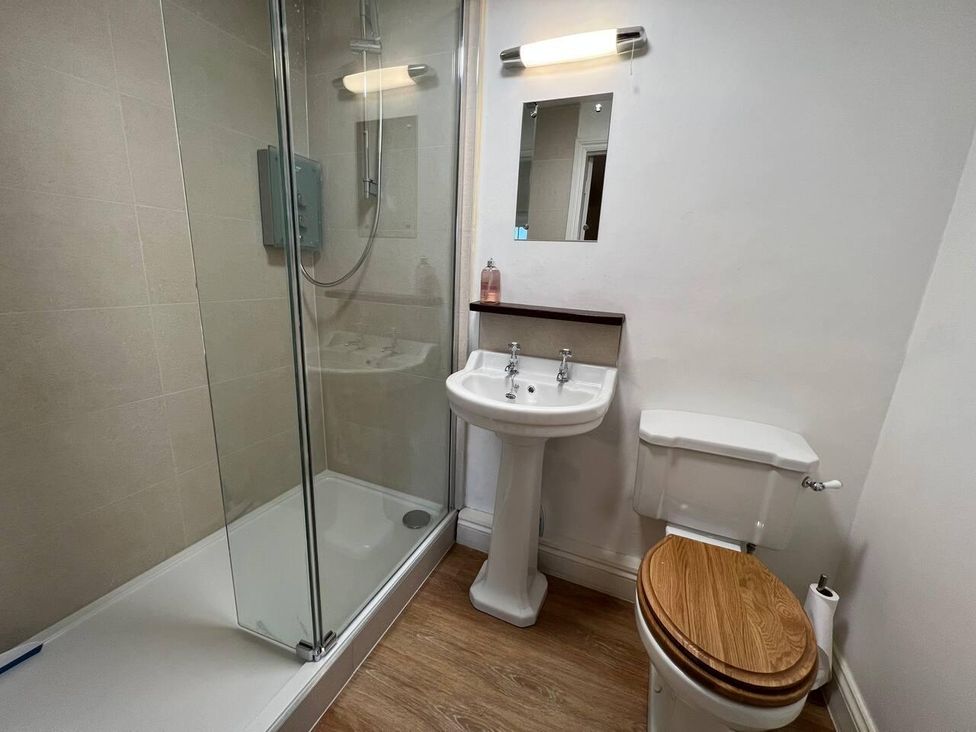 A bathroom with a shower, wash basin, and toilet at House Sleeps 10 Pet friendly Parking in Caldbeck