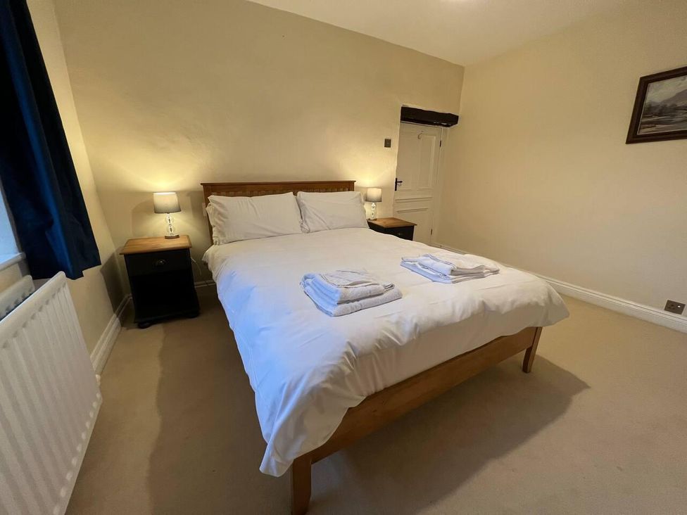 A bedroom with a double bed and bedside table at House Sleeps 10 Pet friendly Parking Caldbeck