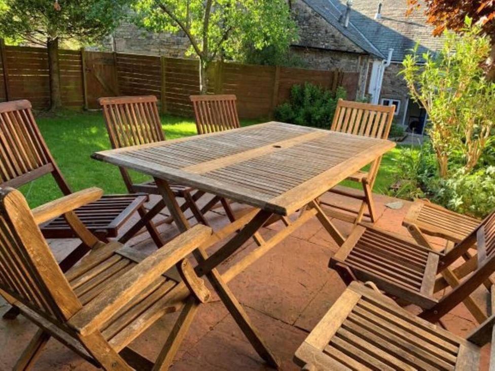 A table and chairs in a garden at House Sleeps 10 Pet friendly Parking Caldbeck