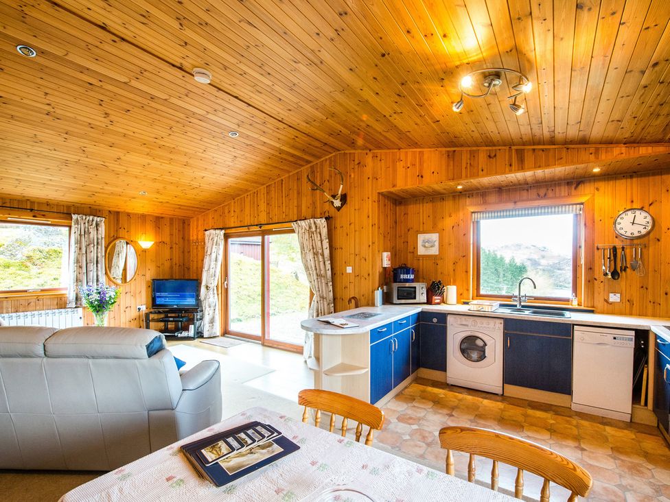 A kitchen with appliances and a dining area at Raven Lodge with beautiful views of Loch Dochart near Crianlarich