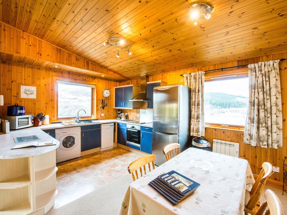 A kitchen with a table and chairs at Raven Lodge with beautiful views of Loch Dochart near Crianlarich