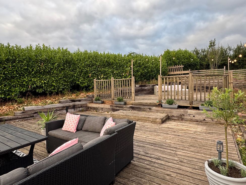 A garden area with seating and decking at Yr Hen Beudy Barn Conversion Sleeps 4 Dogs Ok Brodle Farm near Llansteffan