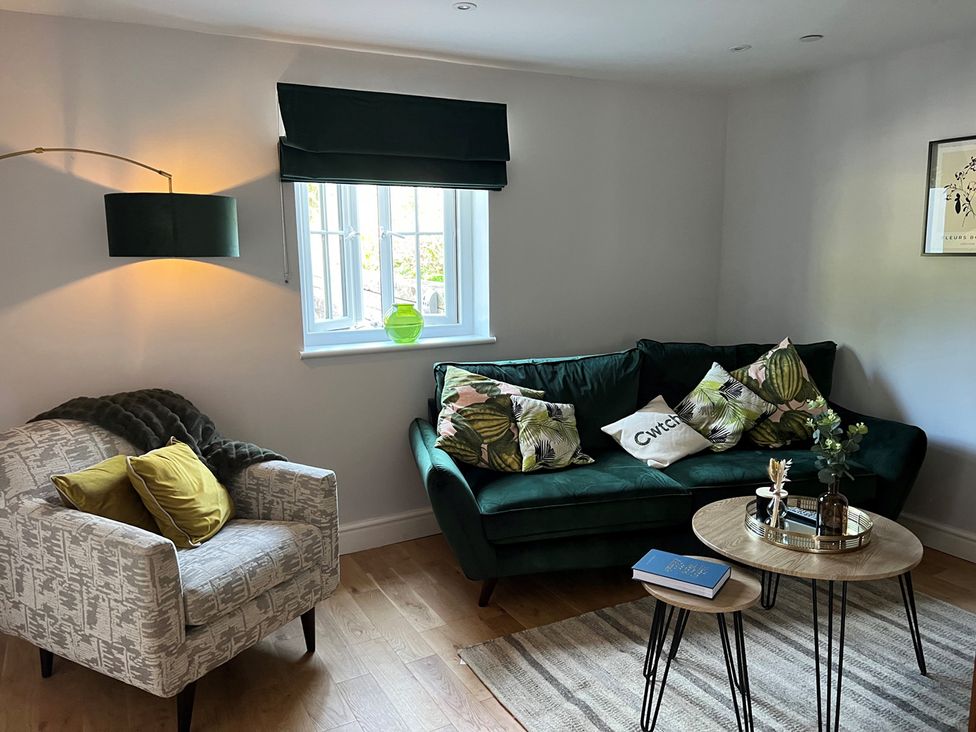 A living room with a sofa, armchair, and coffee table at Yr Hen Beudy Barn Conversion Sleeps 4 Dogs Ok near Brodle Farm near Llansteffan