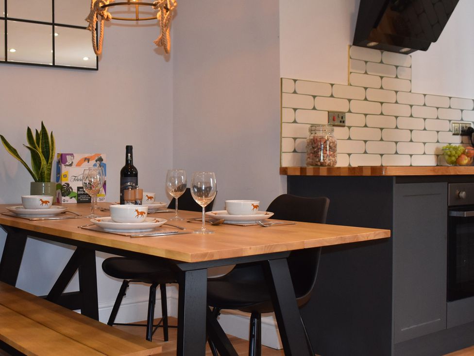 A dining area with a wooden table and chairs at Yr Hen Beudy Barn Conversion Sleeps 4 Dogs Ok near Brodle Farm near Llansteffan