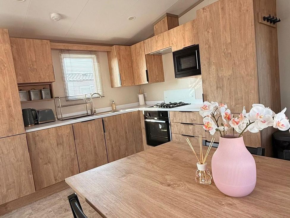A kitchen with cabinets and appliances at 3Bed Sleeps 6 Parking Balcony in Flamingo Land Resort near Kirkby Misperton