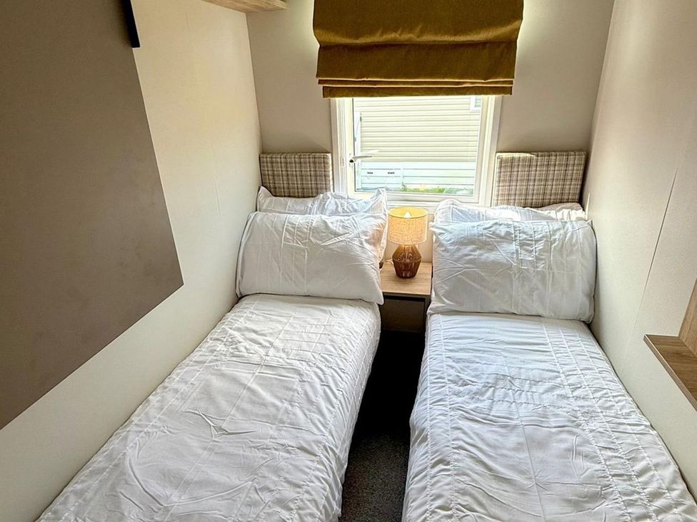 A bedroom with two beds and a lamp at 3Bed Sleeps 6 Parking Balcony in Flamingo Land Resort near Kirkby Misperton