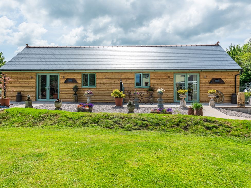 An outdoor view of a wooden building with planters at Paddock View Barn 1Bed Sleeps 4 with Parking, Duffryn Lloff Farm near Cowbridge