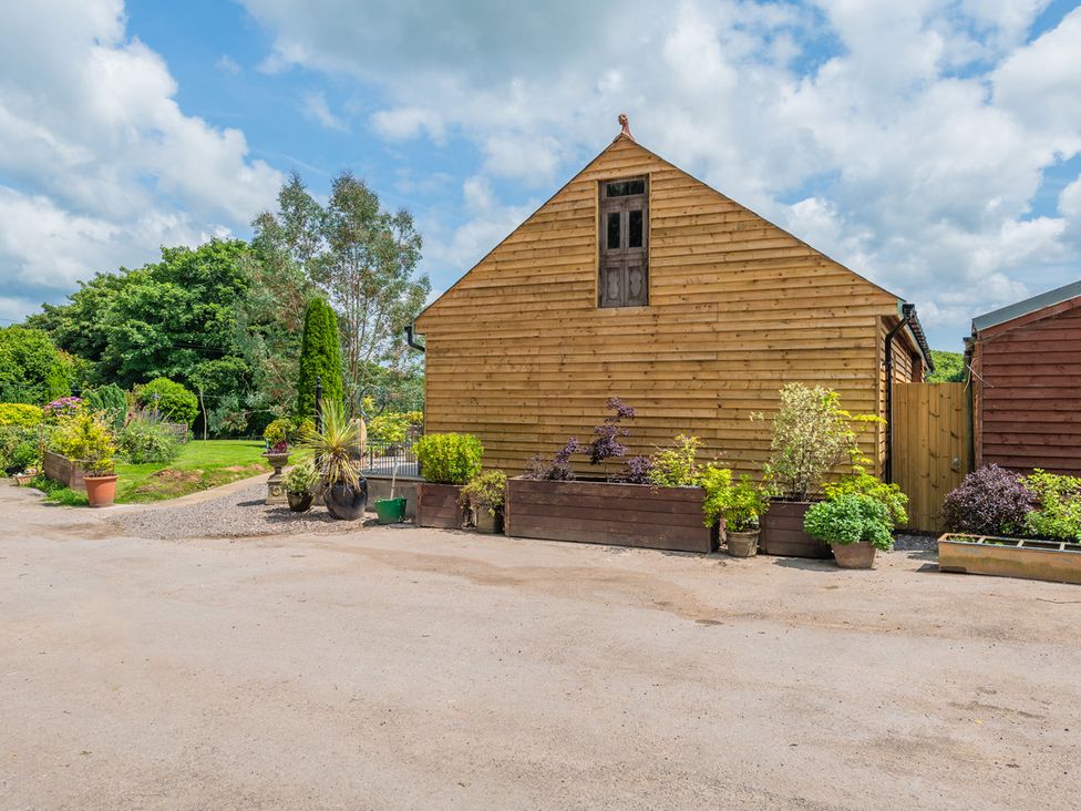 An outdoor area with a wooden building and planters at Paddock View Barn 1Bed Sleeps 4 with Parking Duffryn Lloff Farm near Cowbridge