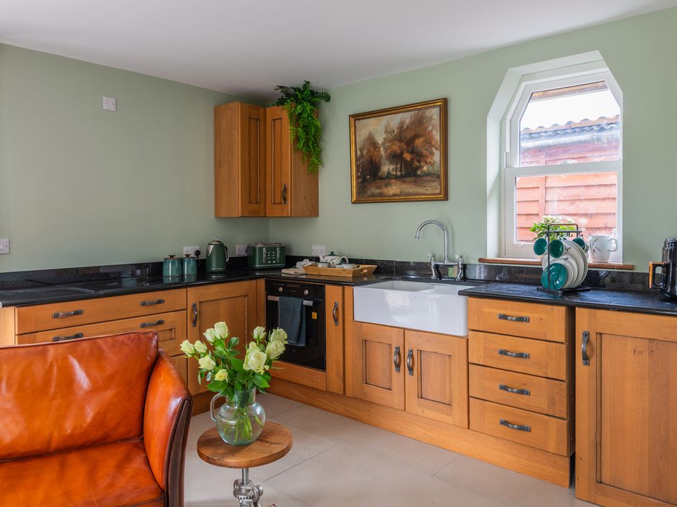 A kitchen with wooden cabinets and a sink at Paddock View Barn 1Bed Sleeps 4 with Parking Duffryn Lloff Farm near Cowbridge