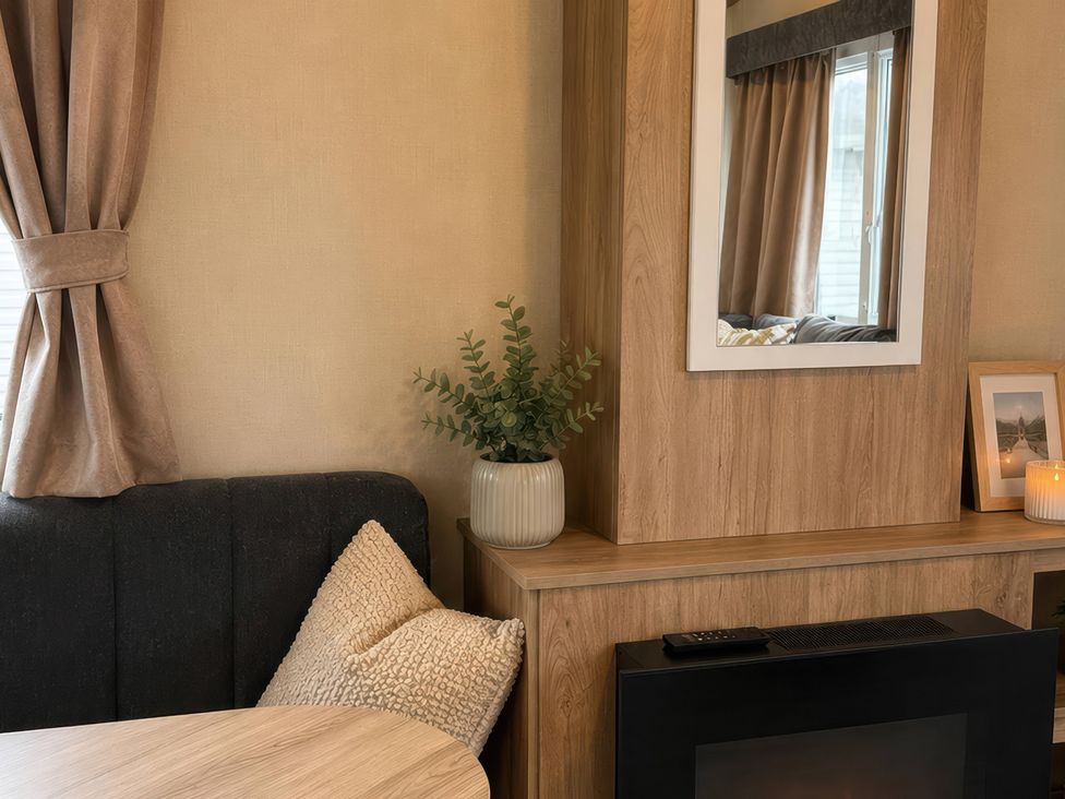 A living room with a couch, table, and plant at a property location