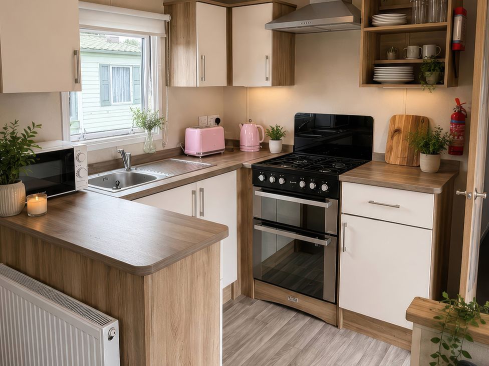 A kitchen with a stove, sink, and microwave at the property in unspecified location