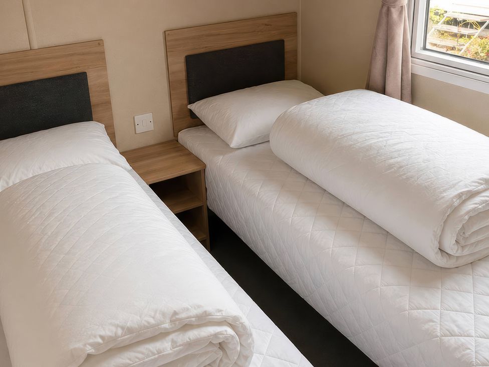 A bedroom with two beds and a bedside table at The Old Barn in Manchester