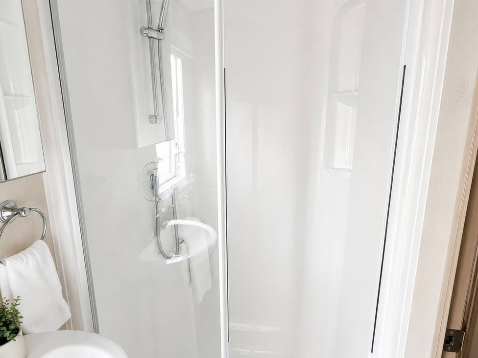 A bathroom with a shower, sink, and towel at an unspecified location