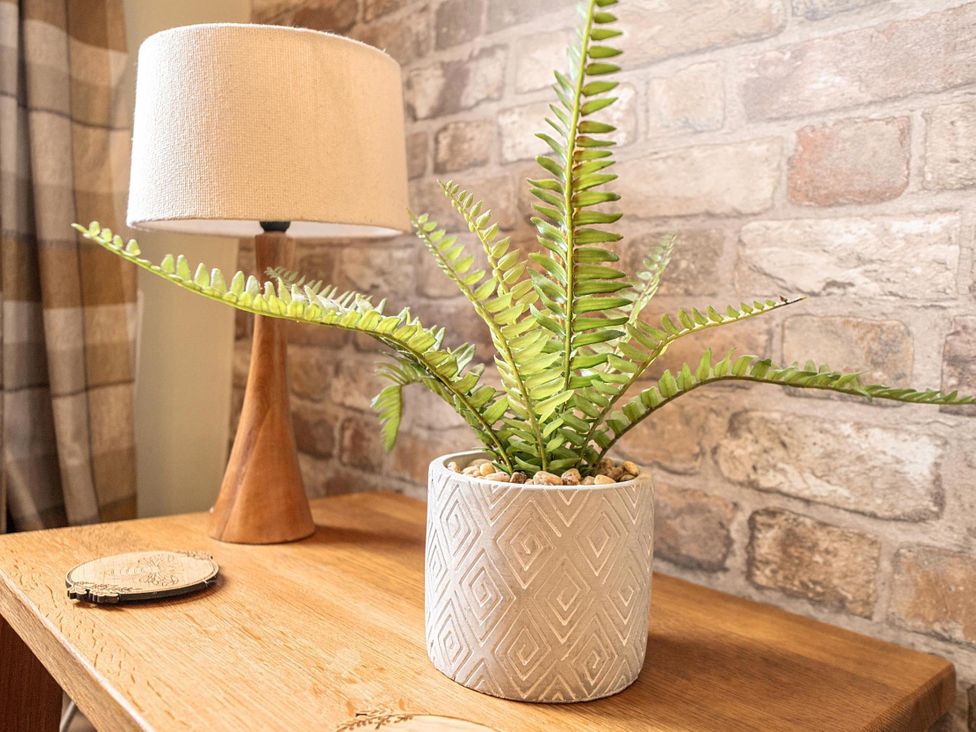 A table with a lamp and a plant at Central Ripon Sleeps 3 Garden Pet Friendly in Ripon