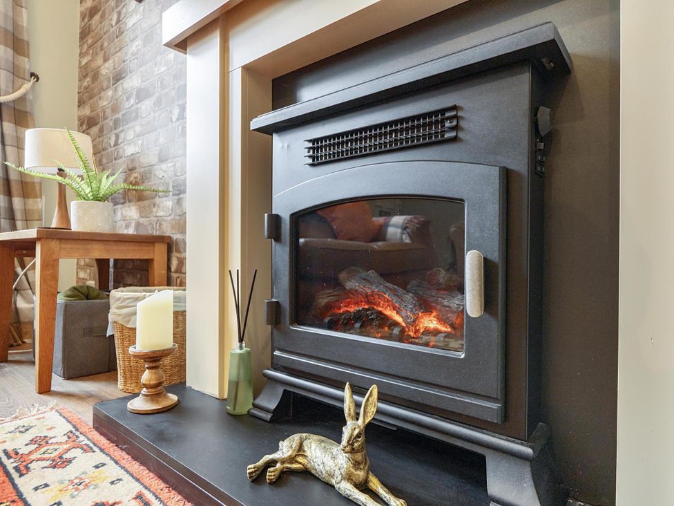 A living room with a fireplace and decorative items at Central Ripon Sleeps 3 Garden Pet Friendly, Ripon