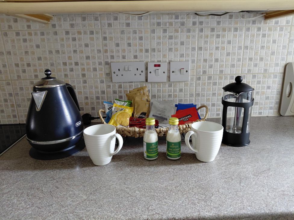A kitchen counter with a kettle, cups, and a coffee press at Central Ripon Sleeps 3 Garden Pet Friendly in Ripon