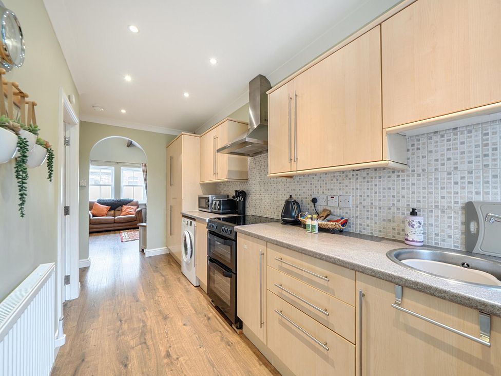 A kitchen with appliances and a view into a living area at Central Ripon Sleeps 3 Garden Pet Friendly in Ripon