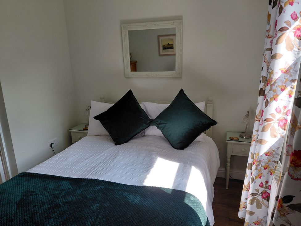 A bedroom with a bed, pillows, and a mirror at Central Ripon Sleeps 3 Garden Pet Friendly Ripon