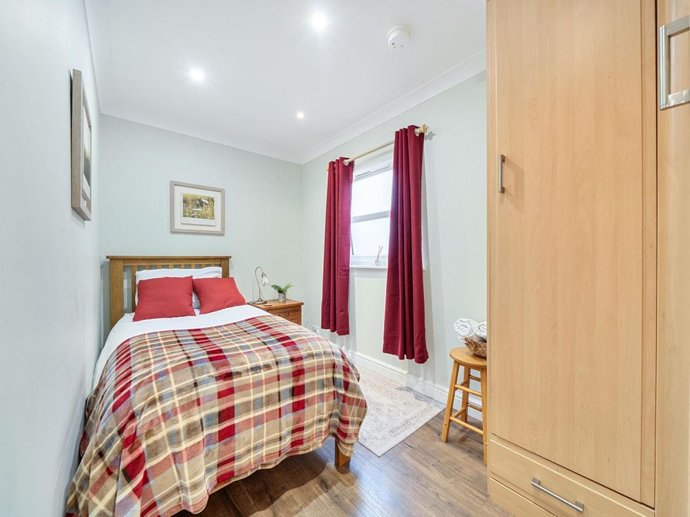 A bedroom with a bed and wardrobe at Central Ripon Sleeps 3 Garden Pet Friendly Ripon