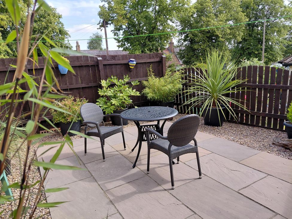 A garden with a table and chairs surrounded by plants at Central Ripon Sleeps 3 Garden Pet Friendly in Ripon