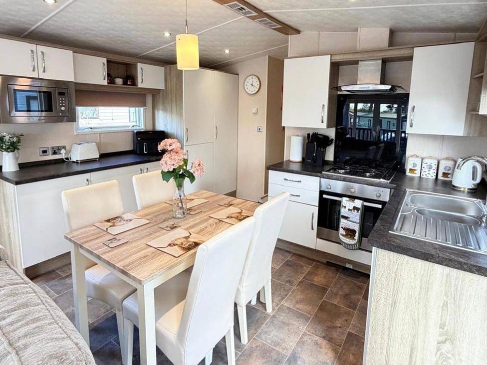 A kitchen with table and chairs at Lillardsedge Luxury Caravan Sleeps 6 with Parking near Lilliardsedge Holiday Park