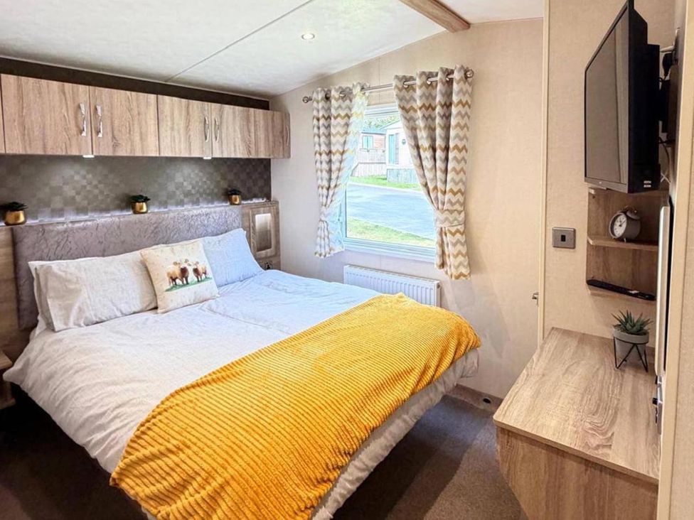 A bedroom with a double bed and a window at Lillardsedge Luxury Caravan Sleeps 6 with Parking near Lilliardsedge Holiday Park near St Boswells
