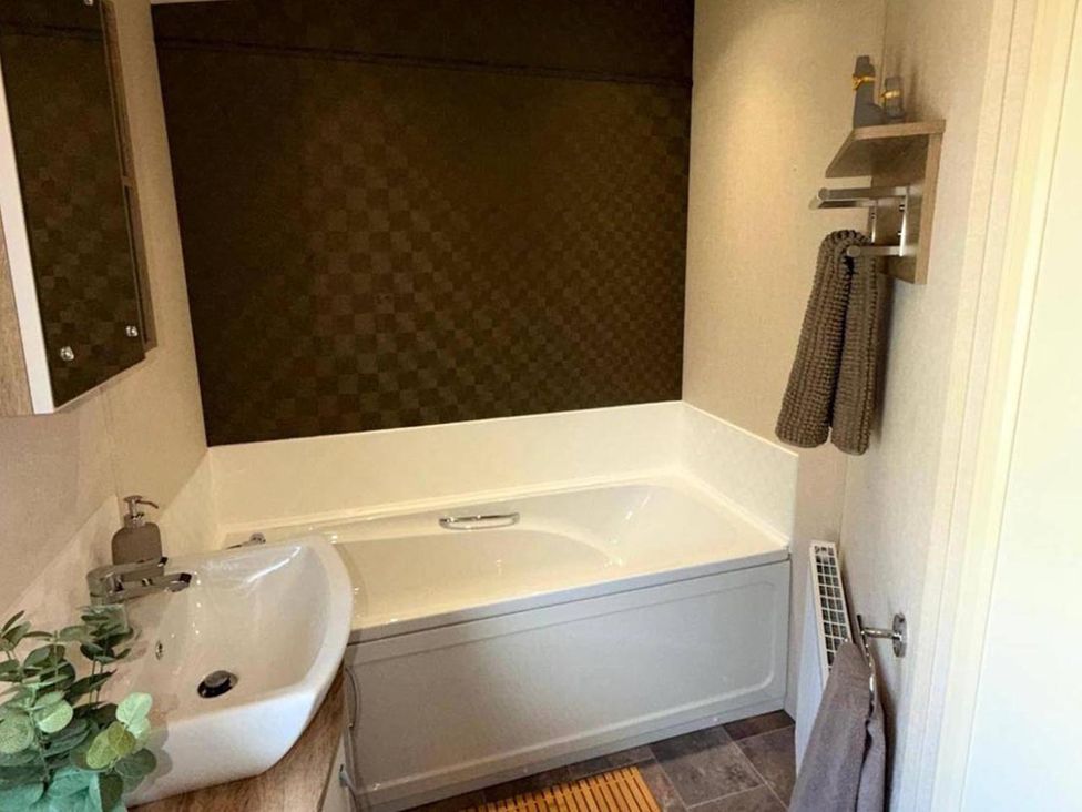 A bathroom with a bathtub and sink at Lillardsedge Luxury Caravan Sleeps 6 with Parking near Lilliardsedge Holiday Park
