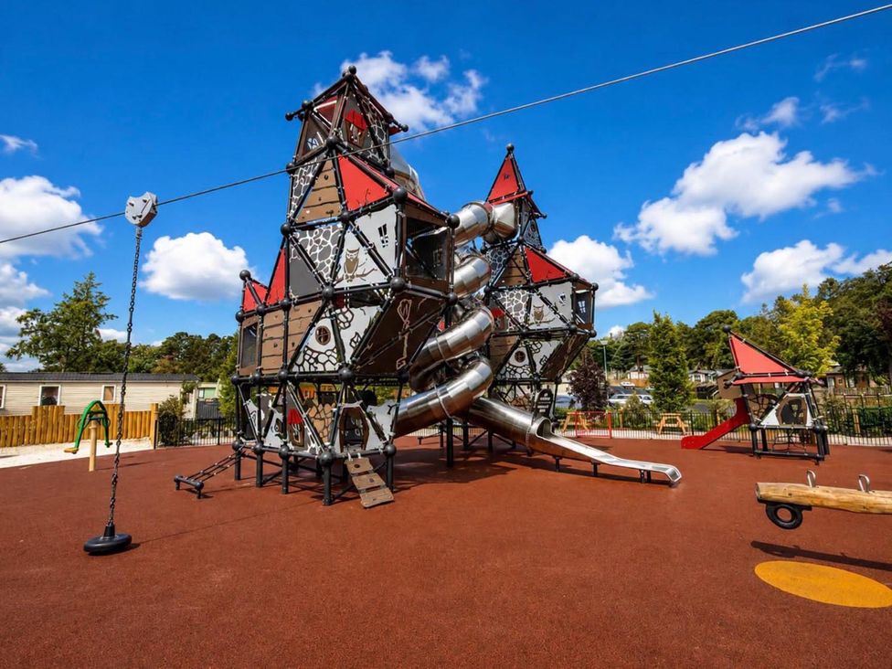 A play structure with slides and swings at a playground