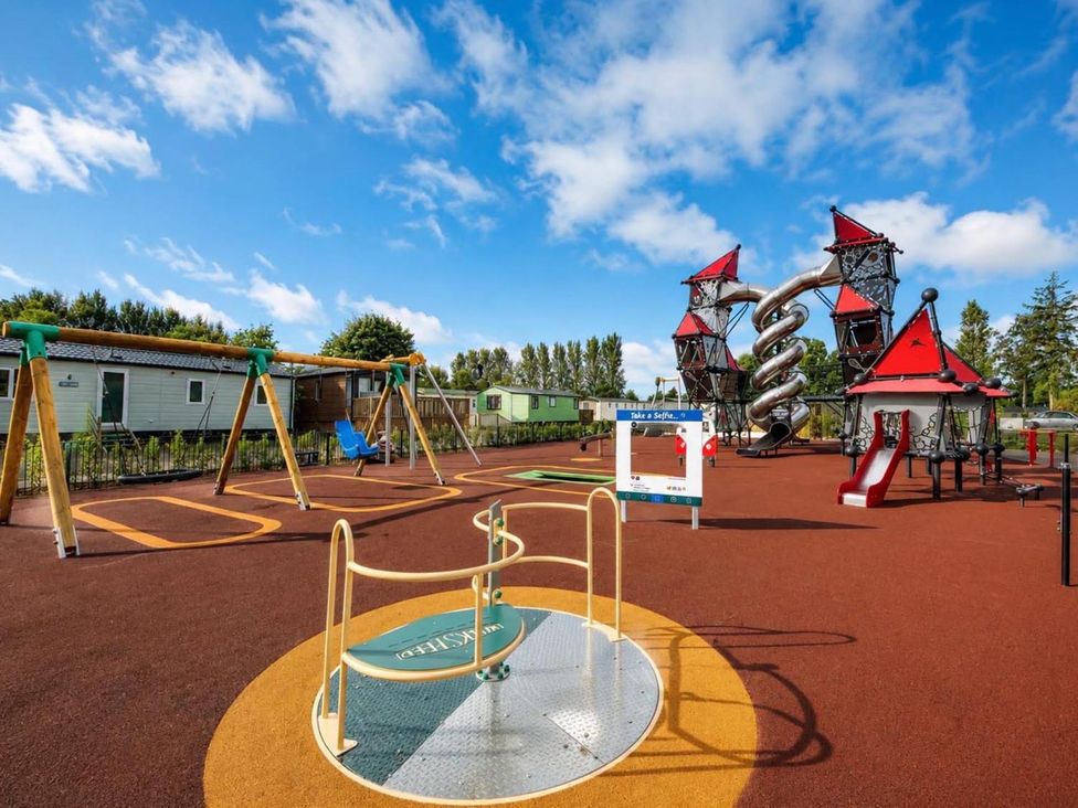 A playground with swings and climbing structures at Lillardsedge Luxury Caravan Sleeps 6 with Parking near Lilliardsedge Holiday Park