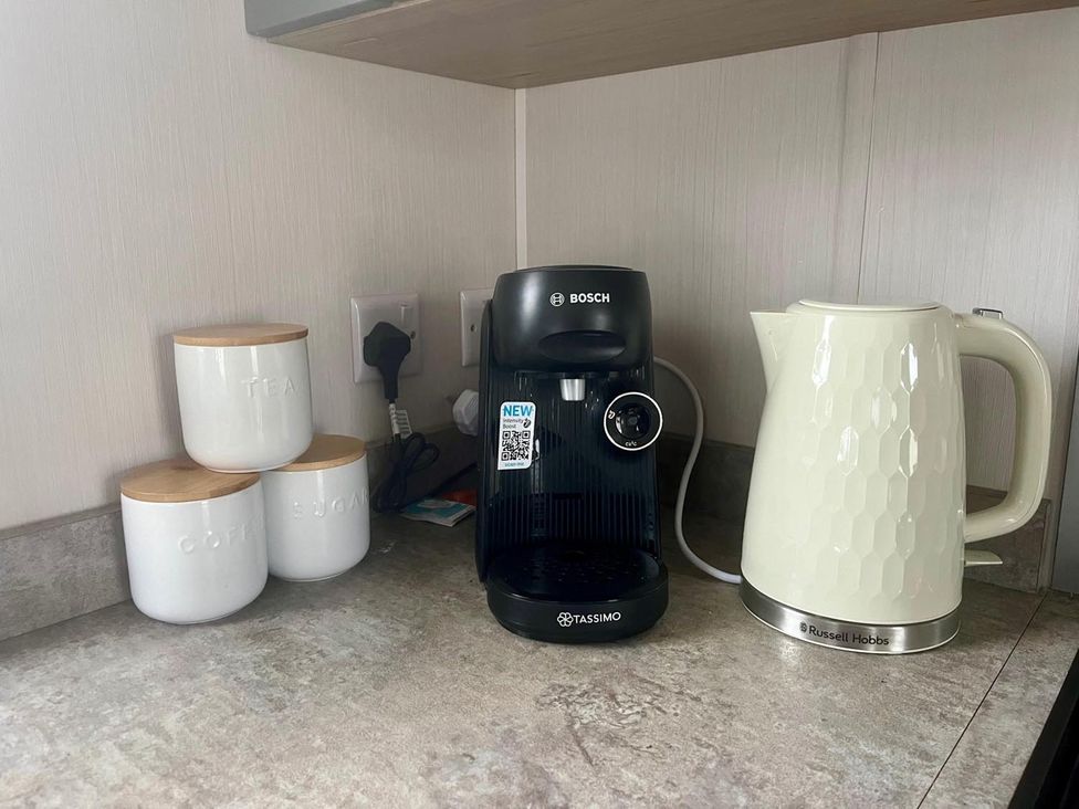 A coffee maker and electric kettle on a countertop at Surfside Bliss Cayton Bay Park caravan in Cayton Bay