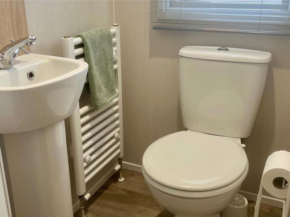 A bathroom with sink and toilet at Surfside Bliss Cayton Bay Park caravan in Cayton Bay