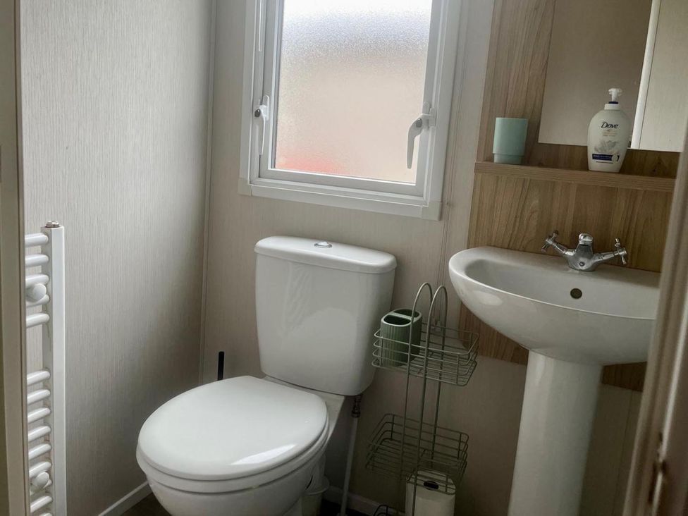 A bathroom with a toilet and sink at Surfside Bliss Cayton Bay Park caravan Cayton Bay