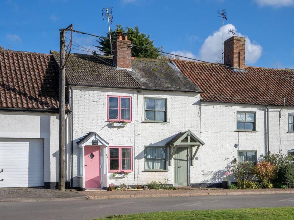 A cottage with a pink front door and garden at 1 Bed Cottage Sleeps 2 with Hot Tub Pets Welcome in Great Massingham